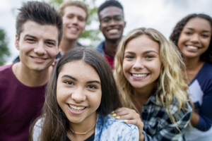 Gruppe junger Frauen und Männer schauen den Betrachter freundlich an